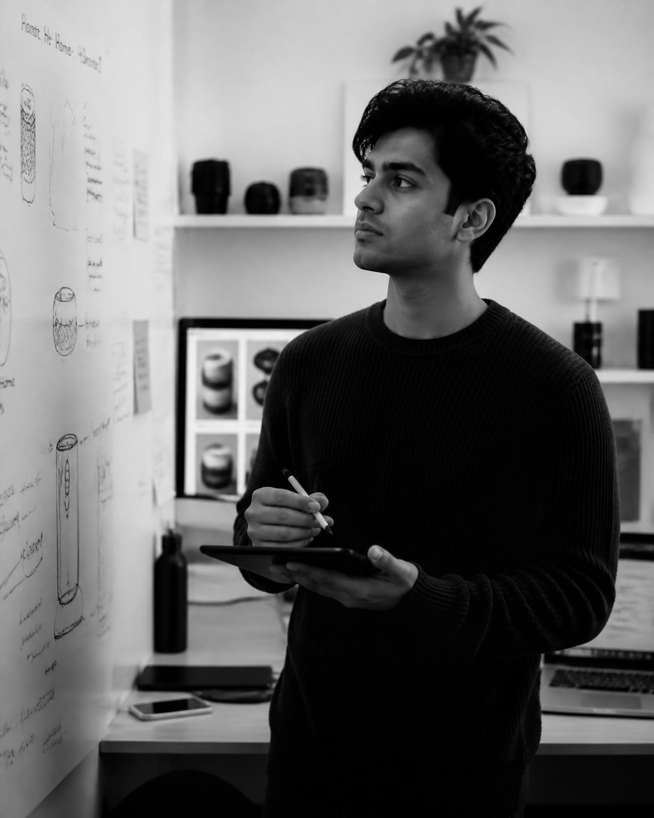 Young builder sketching on a tablet in a product studio